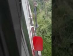 Viral! Pria Ini Bergelantungan di Jembatan Rel KA