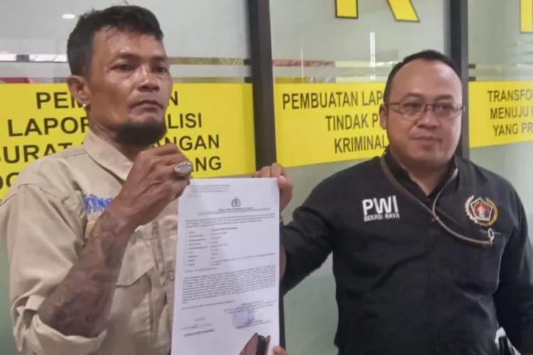 Charles (44) didampingi Ketua PWI Bekasi Raya memperlihatkan bukti laporan Polisi